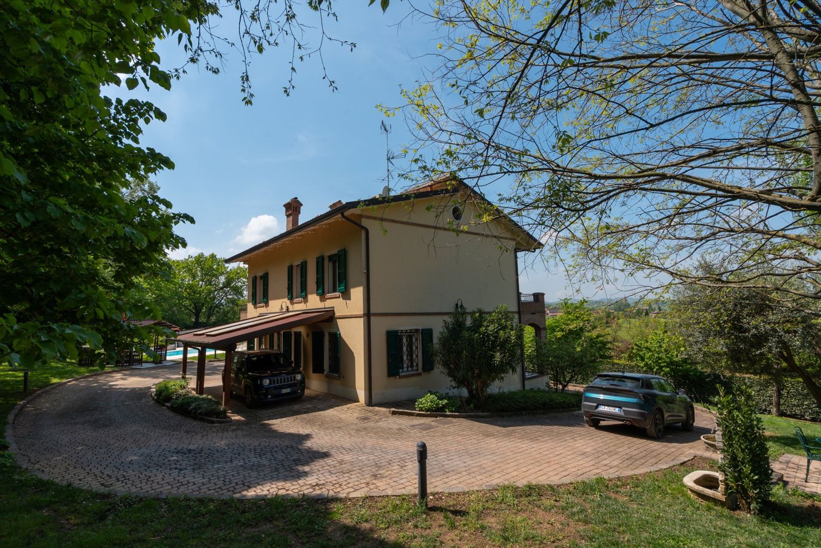 La casa vista dal cortile, tra il verde